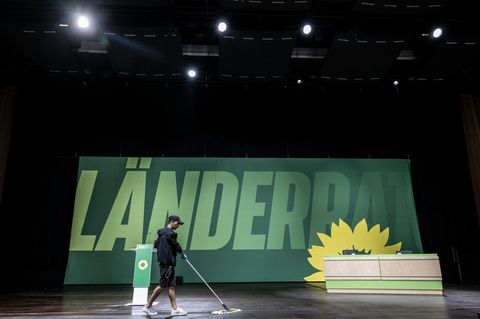 Vor Beginn des Länderrates der Grünen wischt ein Mann die Bühne