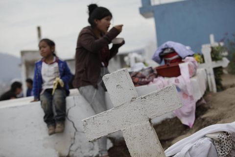 Eine Familie steht auf einem Friedhof in Ecuador. Eine Woche, nachdem sie bei einer Totenwache an ihren Sarg klopfte, ist eine 76-Jährige nun doch gestorben
