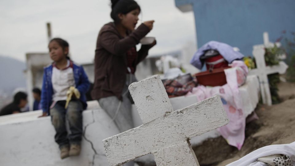 Eine Familie steht auf einem Friedhof in Ecuador. Eine Woche, nachdem sie bei einer Totenwache an ihren Sarg klopfte, ist eine 76-Jährige nun doch gestorben