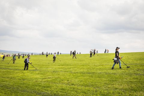 Menschen mit Metalldetektoren auf einem Feld