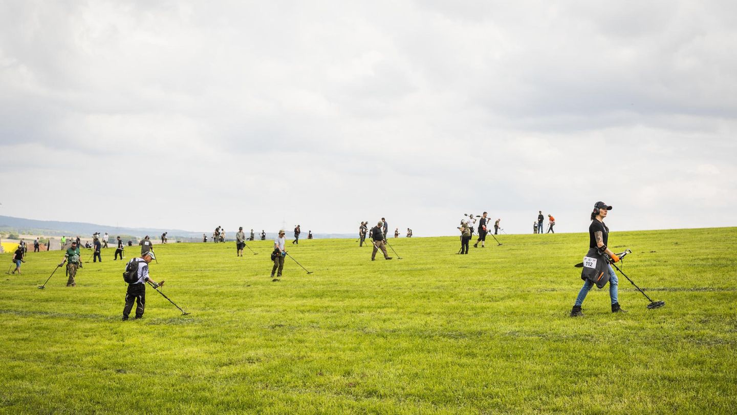 Menschen mit Metalldetektoren auf einem Feld