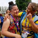 Eine Athletin freut sich mit einer Betreuerin über eine Medaille in Rhythmischer Sportgymnastik