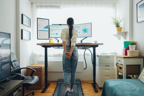 Laufband Schreibtisch: Eine Frau läuft auf einem Laufband unter ihrem Schreibtisch