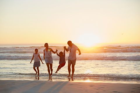 Familie am Strand bei Sonnenuntergang
