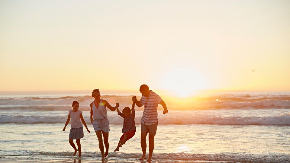 Familie am Strand bei Sonnenuntergang