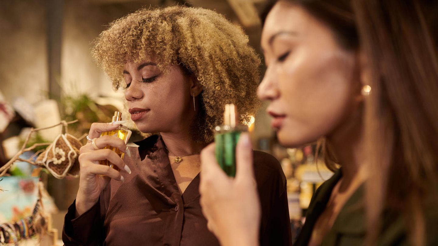 Zwei Personen riechen an Parfum