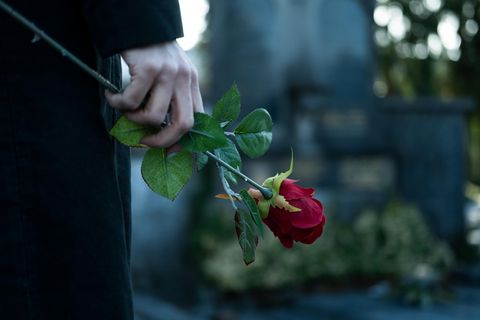 Witwe mit Rose am Grab