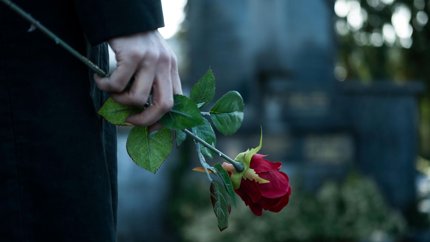 Witwe mit Rose am Grab