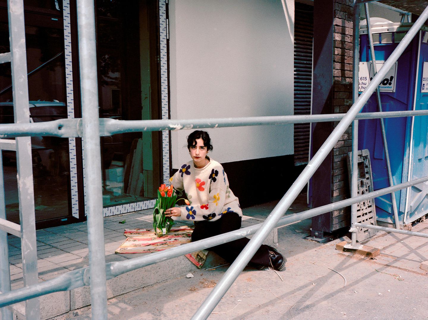 Asli Özçelic platziert einen Blumenstrauß auf einer Baustelle