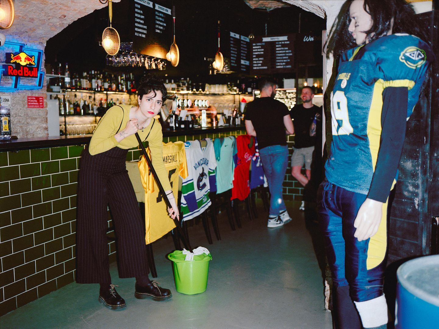 Eine Frau wischt den Boden einer Sportkneipe