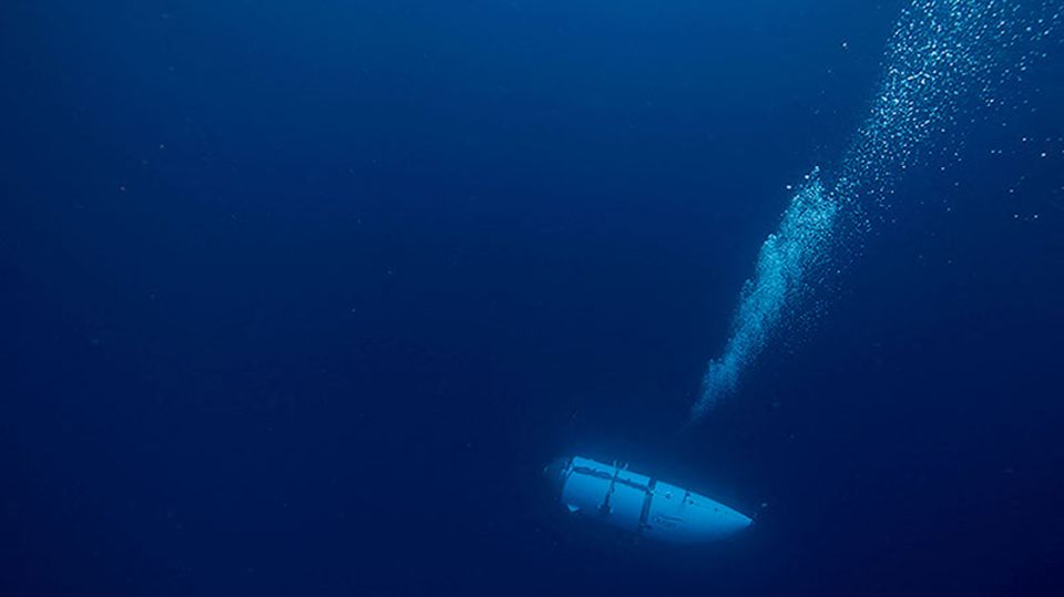 In dunkelblauem Wasser steigen Luftblasen über dem Tauchboot Titan auf