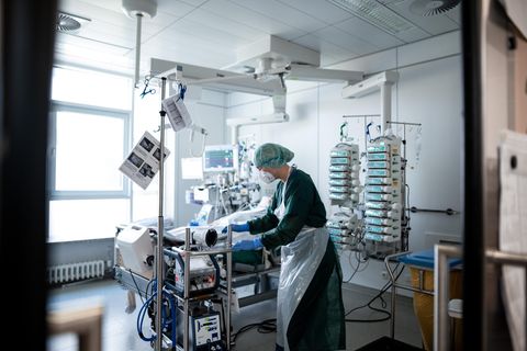 Eine Mitarbeiterin der Pflege steht in einem Zimmer der Corona-Intensivstation