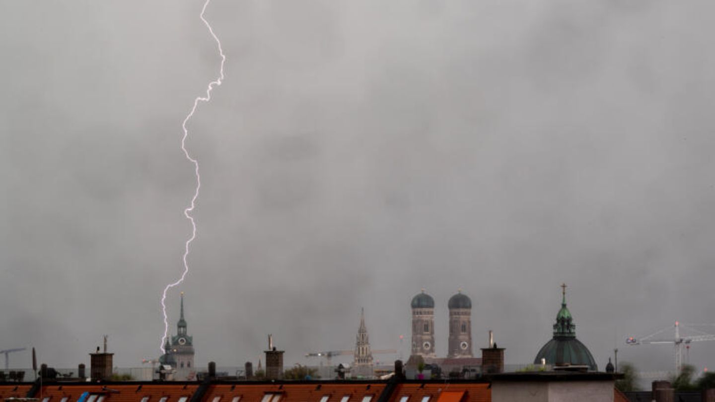 Ein Gewitter mit Blitzen zieht in den Abendstunden über die Dächer der bayerischen Landeshauptstadt.