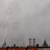 Ein Gewitter mit Blitzen zieht in den Abendstunden über die Dächer der bayerischen Landeshauptstadt.