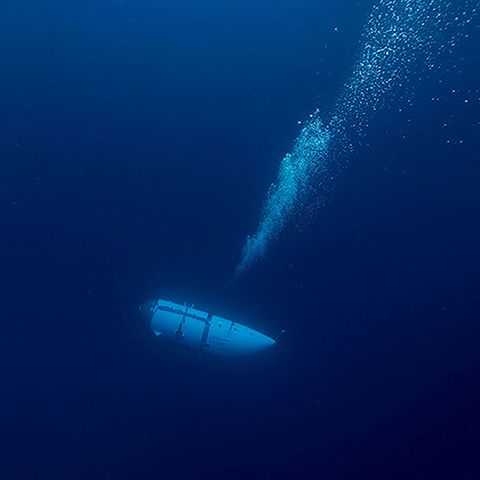In dunkelblauem Wasser steigen Luftblasen über dem Tauchboot Titan auf
