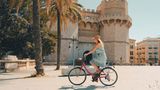 Mit dem Rad vorbei an Palmen, Stränden und historischen Gebäuden fahren, im Nacken die strahlende Sonne, im Ohr der Lieblingssong – eine Radtour durch Valencia lohnt sich aus vielen Gründen. Mit nur 106 Regentagen im Jahr und einem Streckennetz von insgesamt 150 Kilometern bietet die spanische Küstenstadt gute Bedingungen für eine Radreise. Radfahrer sollten allerdings nicht allzu leicht aus der Puste kommen – es erwartet sie ein Höhenunterschied von bis zu 352 Metern. 
