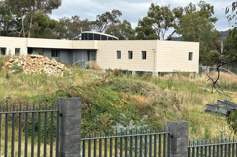 Ein Zaun umgibt ein scheinbar unbewohntes Gebäude auf dem Gelände einer geplanten neuen russischen Botschaft in Australien
