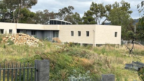 Ein Zaun umgibt ein scheinbar unbewohntes Gebäude auf dem Gelände einer geplanten neuen russischen Botschaft in Australien