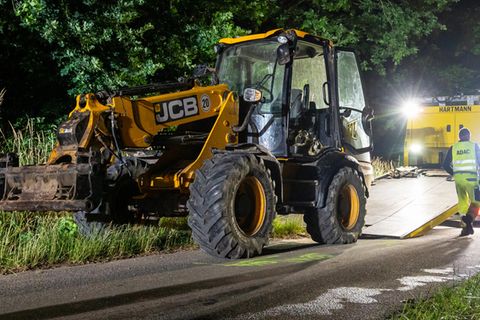 Nach dem Unglück im Kreis Harburg wird der am Unfall beteiligte Bagger abgeschleppt. Ein Kind und ein Mann, beide Teilnehmer eines Zeltlagers, sind bei dem Unfall gestorben.