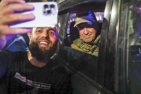 Ein Mann macht ein Selfie mit dem in einem Auto sitzenden Prigoschin
