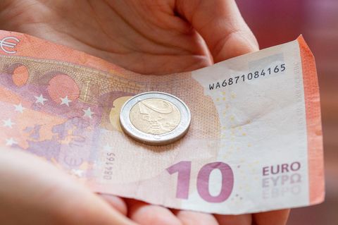 Eine Person hält 12 Euro in der Hand