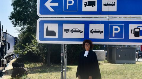 Pfarrerin Bea Ackermann vor dem Schild, das auf die Autobahnkirche hinweist