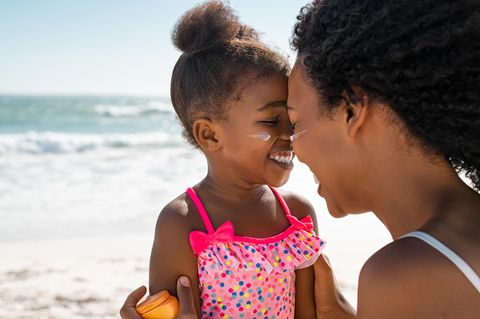 Kind am Strand hat Sonnencreme im Gesicht