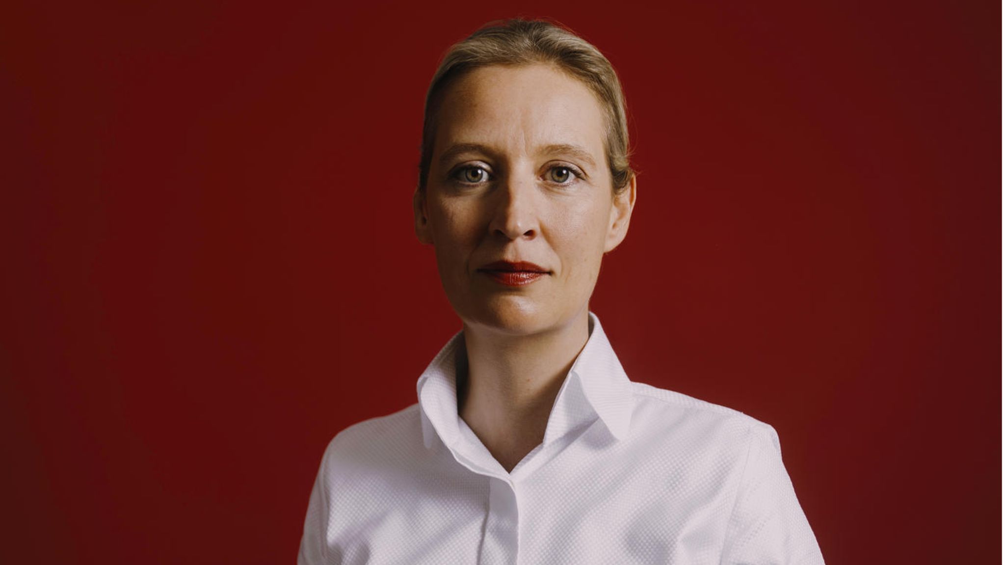 Alice Weidel steht vor einer Wand und schaut in die Kamera