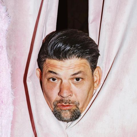 Der Kopf von Tim Mälzer blickt durch einen pinken Vorhang