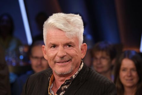 Heinz Strunk, ein Mann mit Tolle, lächelt in die Kamera