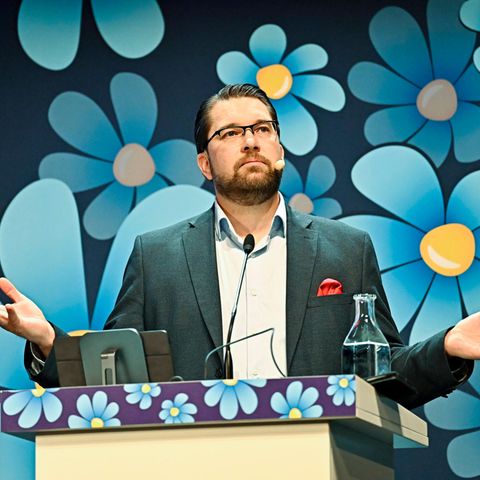 Parteichef Jimmie Åkesson von den Schwedendemokraten vor blau-gelben Blütenlogos
