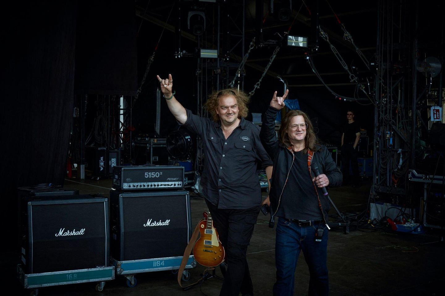 Die beiden Gründer werden in der Gegenwart gespielt von Charly Hübner (Holger Hübner, l.) und Aurel Manthei (Thomas Jensen). Ihr Auftritt beim Wacken Open Air 2022 bildet aber nur die Rahmenhandlung.