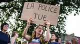 "Polizei tötet" steht auf dem Schild dieser Demonstrantin