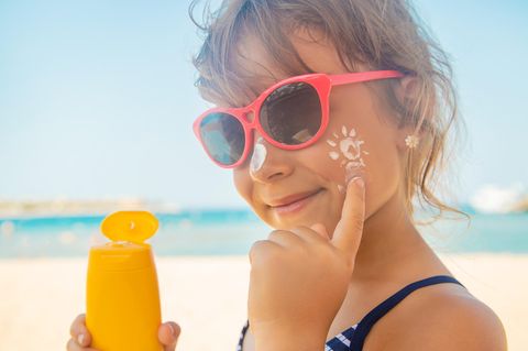 Mädchen trägt Sonnencreme auf