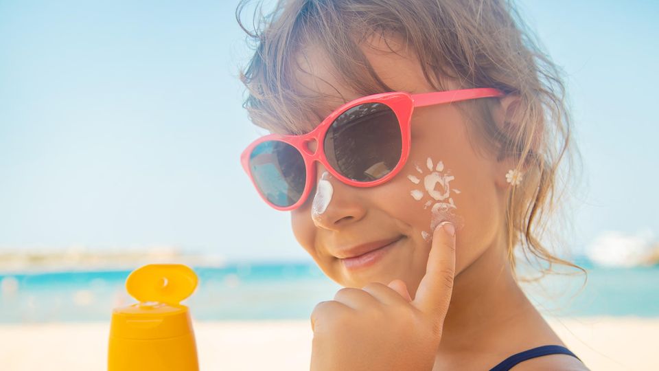 Mädchen trägt Sonnencreme auf