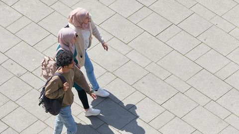 Drei junge Muslime laufen über einen Platz in Magdeburg