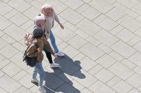 Drei junge Muslime laufen über einen Platz in Magdeburg