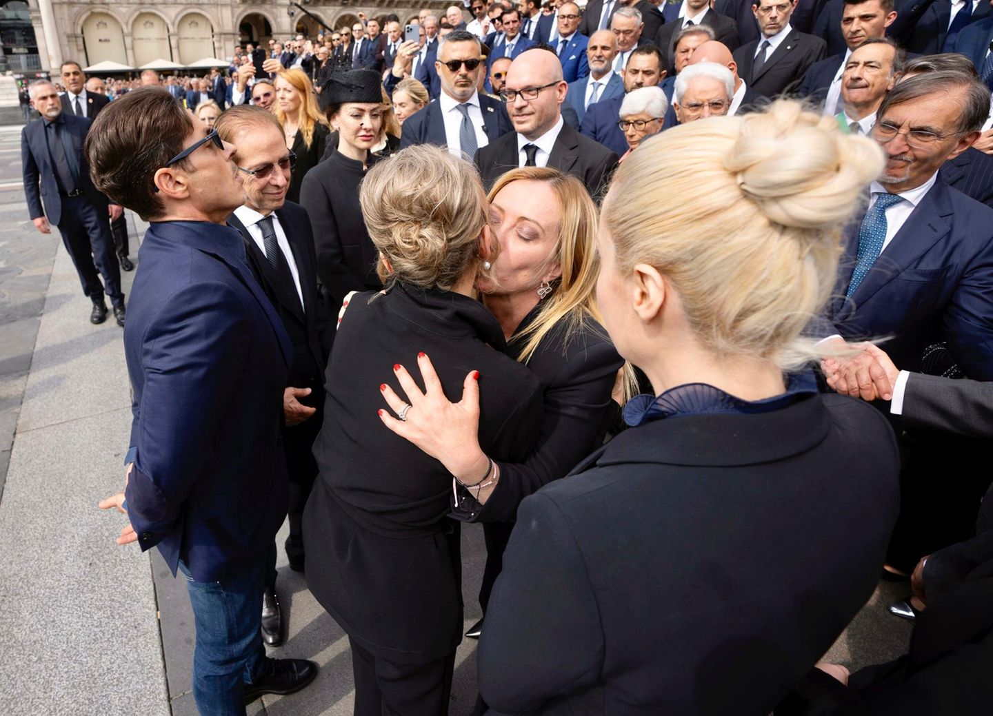 Staatsbegräbnis Berlusconi Premierministerin Giorgia Meloni umarmt Mitglieder der Familie Berlusconi. Eine Frau umarmt eine andere.