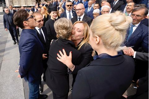 Premierministerin Giorgia Meloni umarmt Mitglieder der Familie Berlusconi. Eine Frau umarmt eine andere.