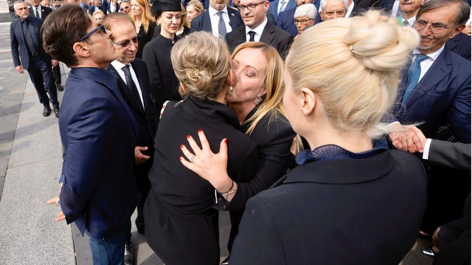 Premierministerin Giorgia Meloni umarmt Mitglieder der Familie Berlusconi. Eine Frau umarmt eine andere.