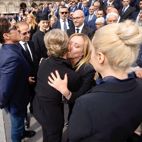 Premierministerin Giorgia Meloni umarmt Mitglieder der Familie Berlusconi. Eine Frau umarmt eine andere.
