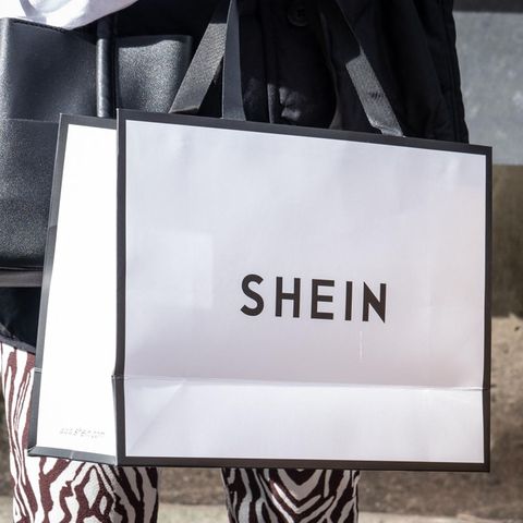 Eine Person trägt eine Shoppingtüte des Modekonzerns Shein