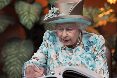 Queen Elisabeth II. schreibt in ein Gästebuch