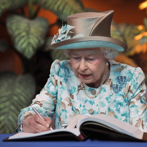 Queen Elisabeth II. schreibt in ein Gästebuch