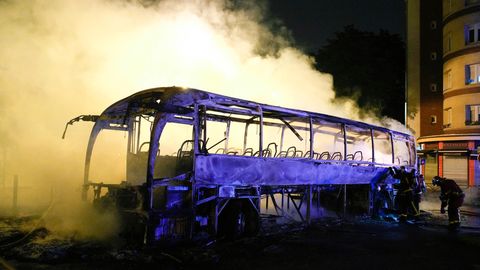 Frankreich, Nanterre: Rauch steigt bei nächtlichen Krawallen aus einem ausgebrannten Bus.