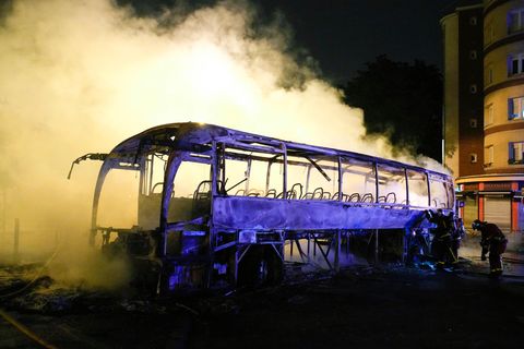 Frankreich, Nanterre: Rauch steigt bei nächtlichen Krawallen aus einem ausgebrannten Bus.