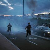 Menschen fliehen auf der Straße in Lyon, während es zu einem Zusammenstoß mit der Polizei kommt.