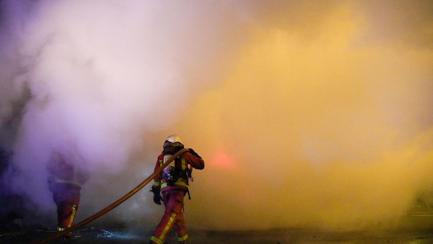 In Nanterre, bei Paris, löschen Feuerwehrleute Flammen.