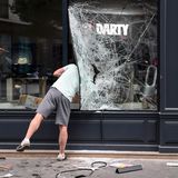 Ein Mann begutachtet am Sonntamorgen den Schaden in einem Geschäft in Lyon.