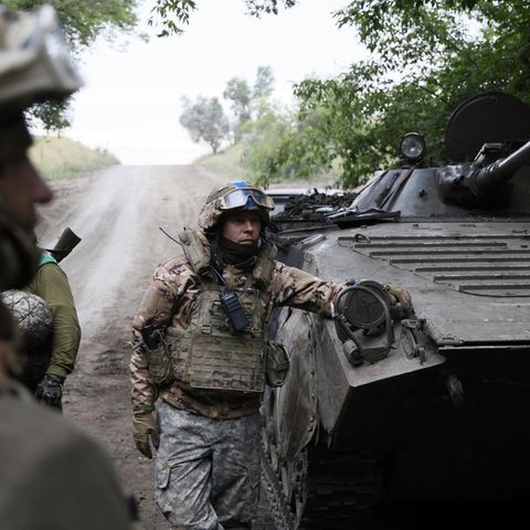 Ukrainische Soldaten neben einem gepanzerten Transporter.